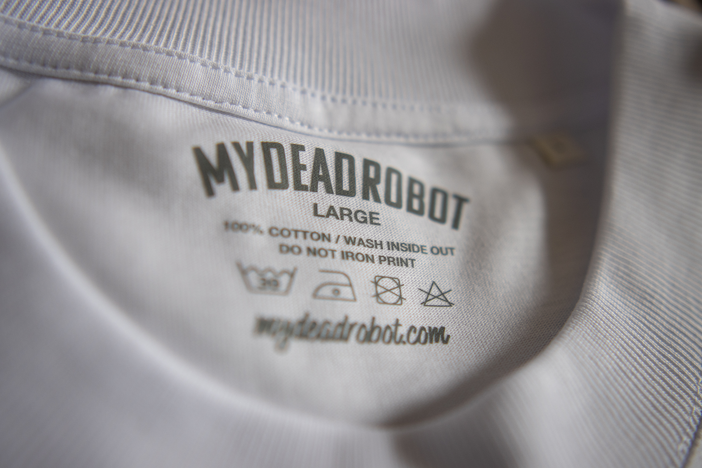 Close-up of a 'My Dead Robot' label on a shirt with washing instructions.