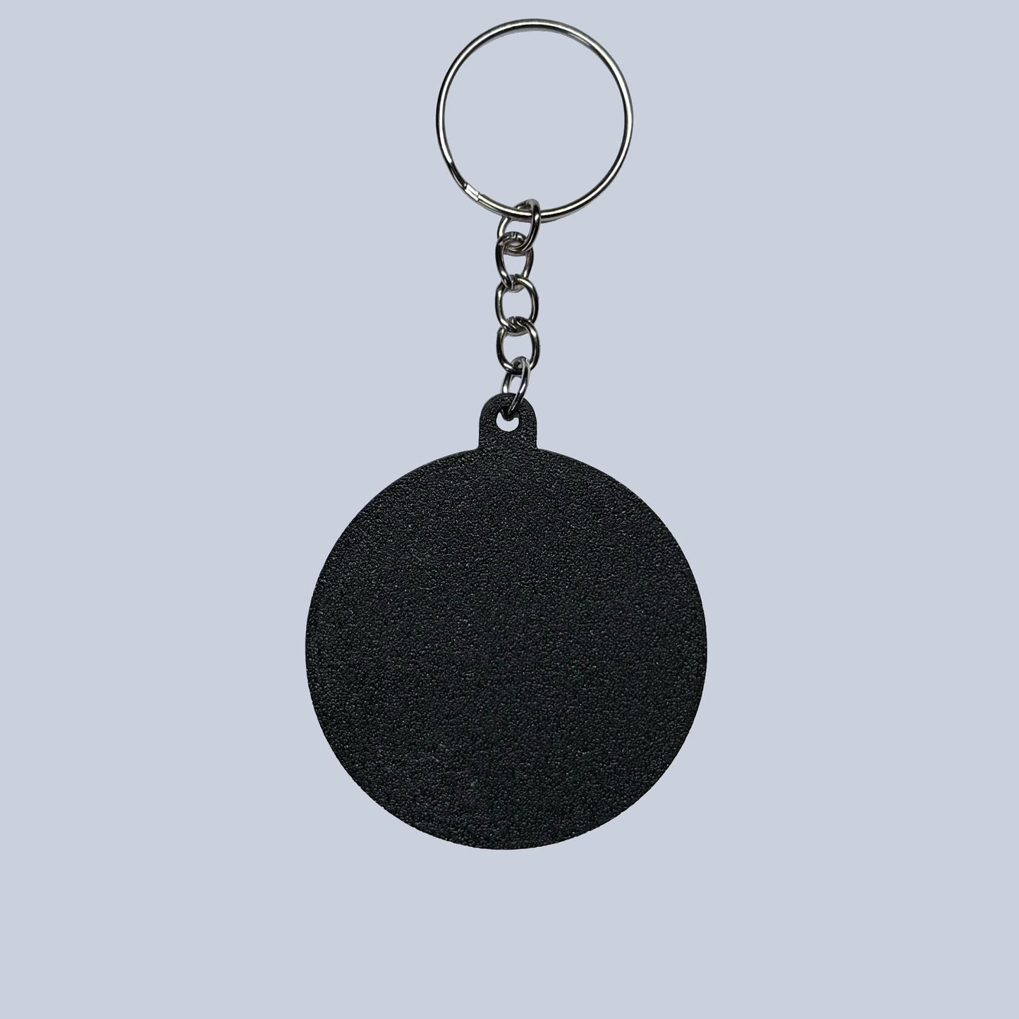 Black round keychain on a light gray background