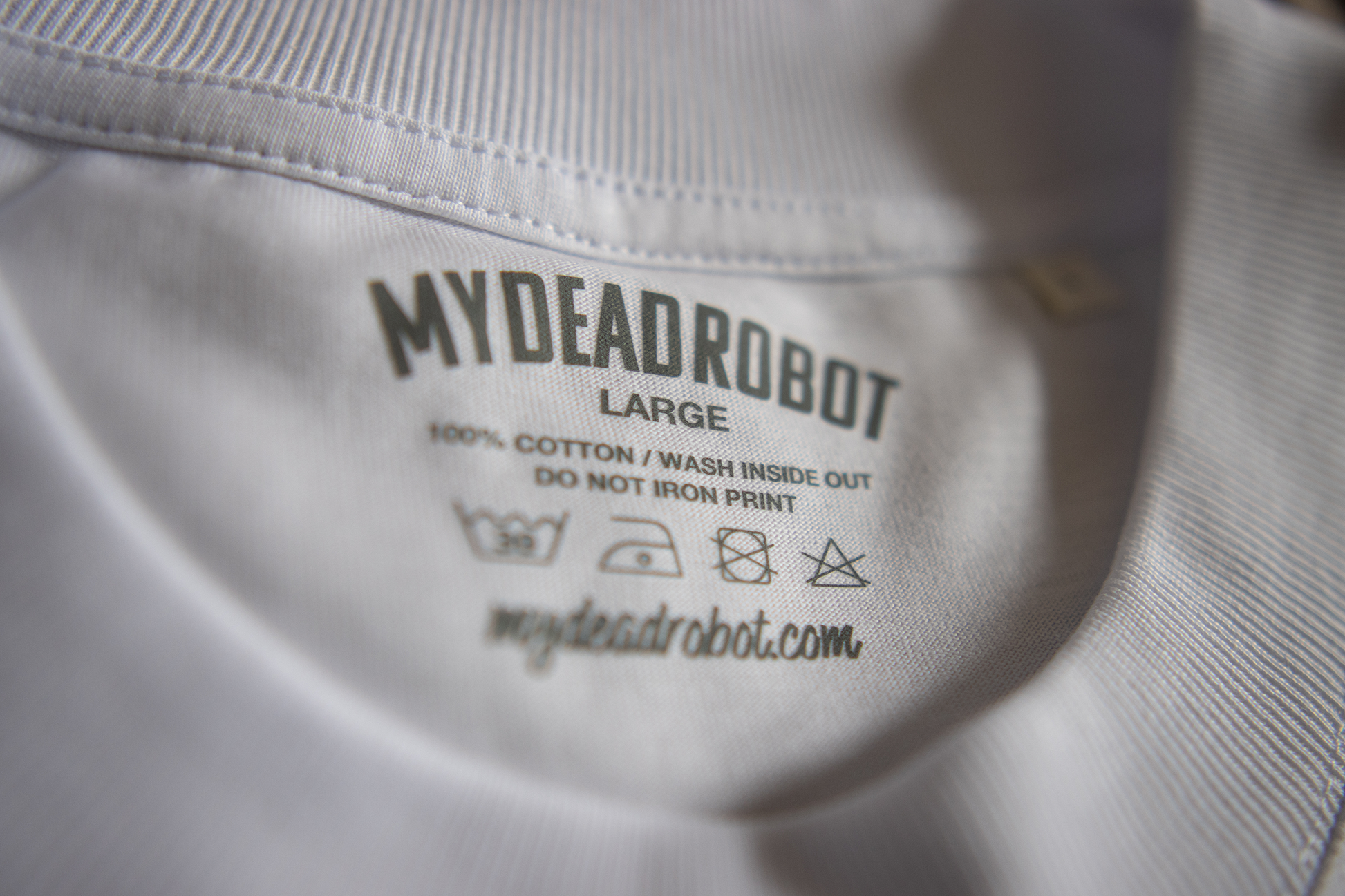 Close-up of a 'My Dead Robot' label on a shirt with washing instructions.