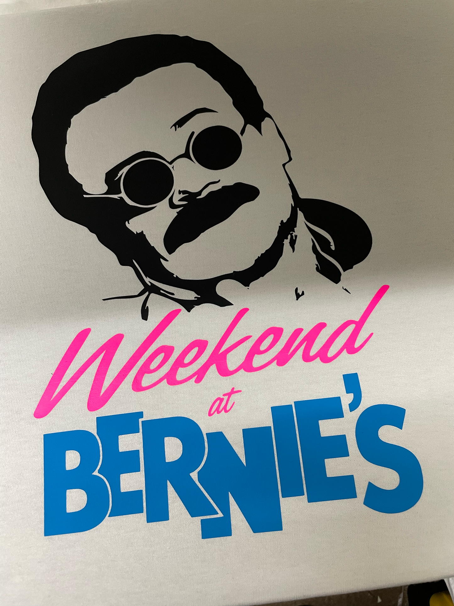 Illustration with a stylized face and 'Weekend at Bernie's' text on a white background